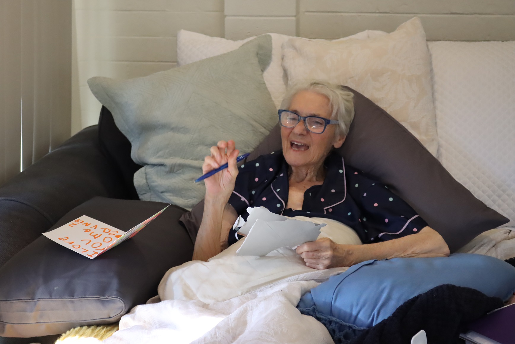 palliative client at home in bed sings as part of music therapy session